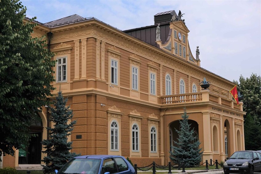 A historic building with ornate architecture, including a clock tower and statues. 3