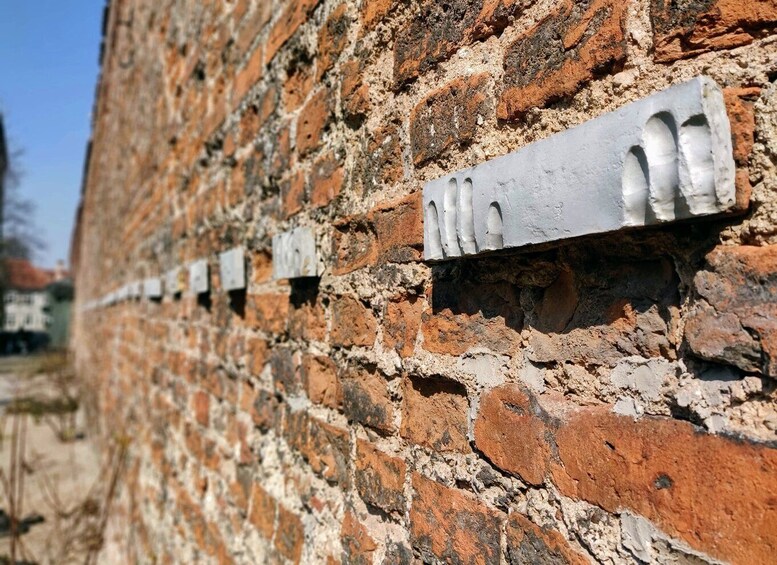 A brick wall with metal plaques. 4