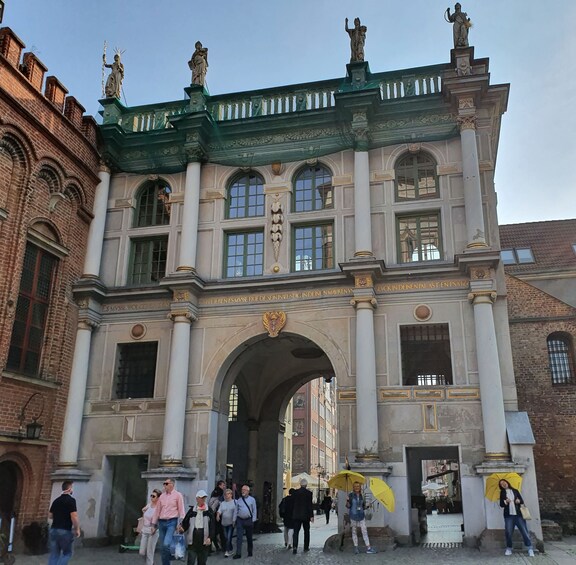 A historic building with ornate architecture, including statues and an archway. 5