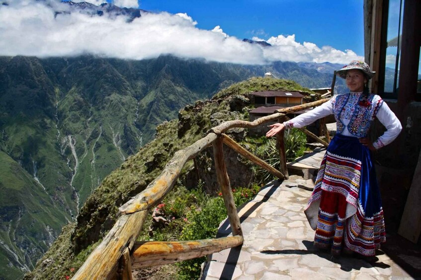 A person standing on a stone pathway with a mountainous landscape in the background. 3