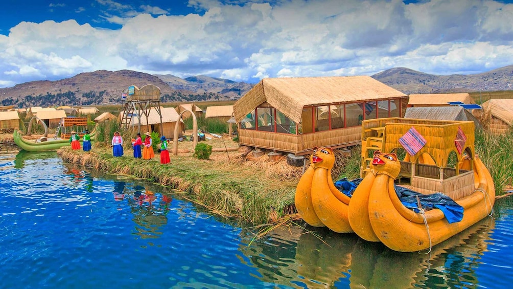 A traditional village with thatched-roof houses, a river, and a large, colorful sculpture of a bird. 3