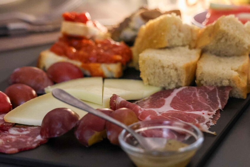 A charcuterie board with various meats, cheeses, and bread. 2
