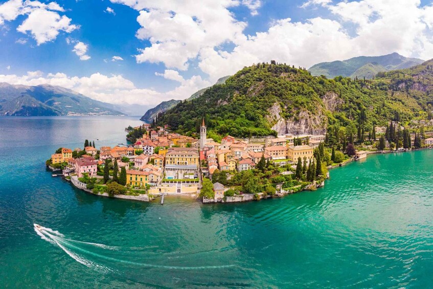A picturesque lakeside town with colorful buildings, a prominent church, and lush greenery. 3