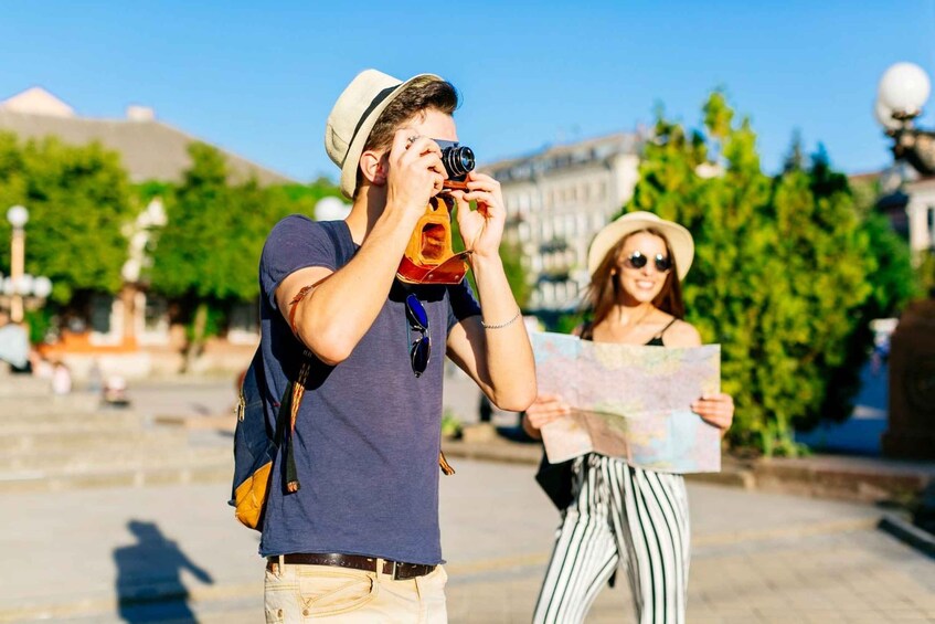 A person taking a photo with a camera and another person holding a map. 4