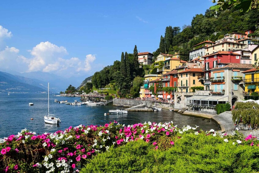 A coastal town with colorful buildings, a harbor with boats, and lush greenery. 1