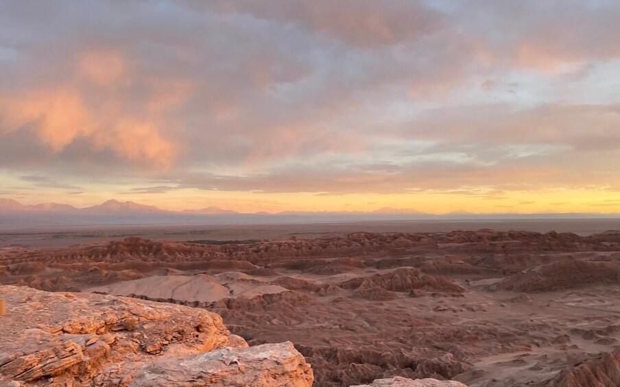 A rugged landscape with eroded rock formations and a vast horizon under a cloudy sky. 4