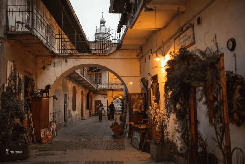 An old European street with a covered passageway, antique furniture, and a clock on the wall. 4