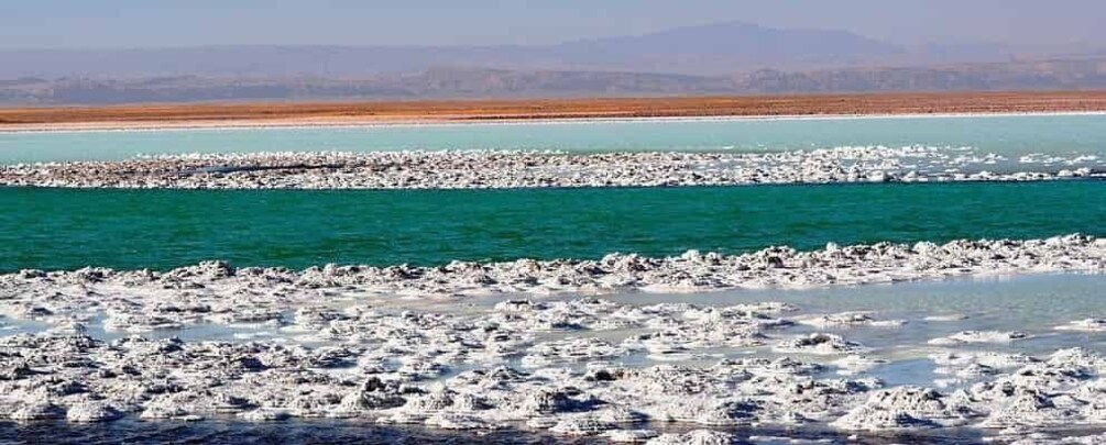 Una planicie salina con formaciones blancas de sal y agua turquesa. 1