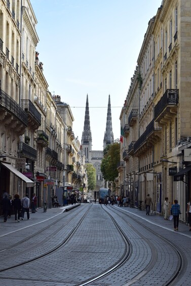 A cobblestone street lined with historic buildings and a church spire in the background. 5