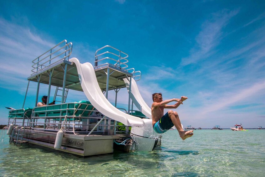 A person jumping off a boat with a water slide. 5