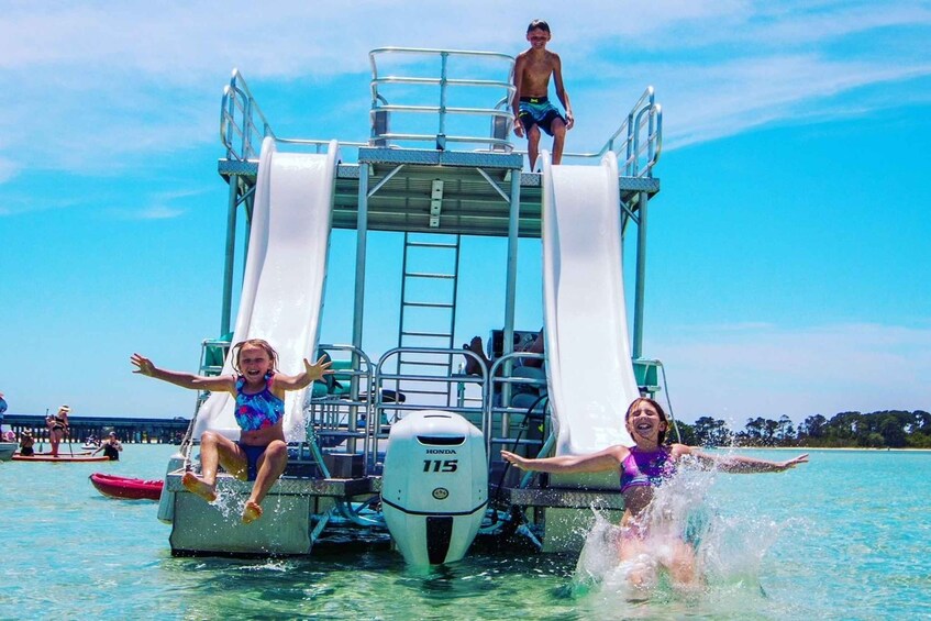A water slide on a boat with people sliding down. 1