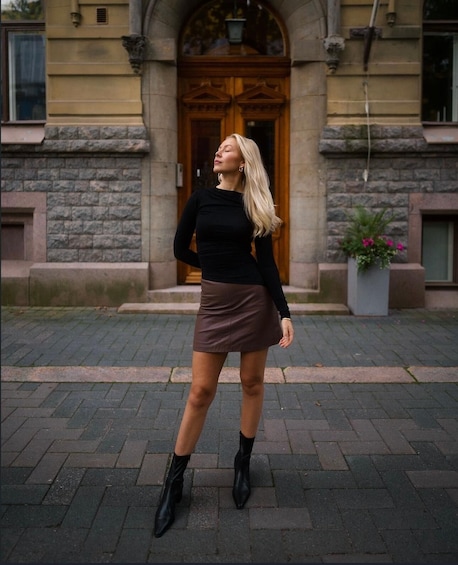 A person standing in front of a building with a stone facade and a wooden door. 4