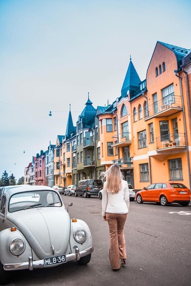 A street with colorful buildings and a vintage car. 5