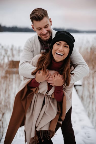 A couple embracing on a snowy path with a lake in the background. 2