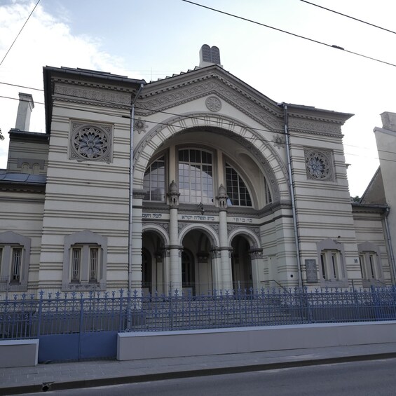 Un edificio histórico con detalles arquitectónicos ornamentales, incluyendo una gran entrada arqueada y relojes decorativos. 3