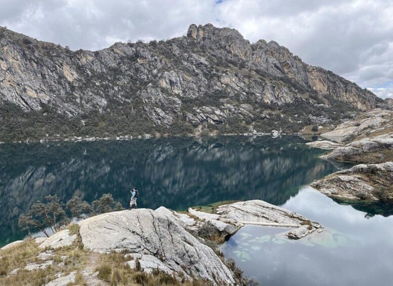 A mountainous landscape with a clear lake reflecting the sky and surrounding peaks. 3