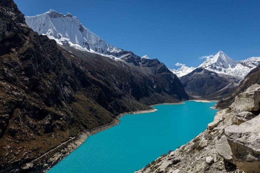 A turquoise lake surrounded by rugged mountains with snow-capped peaks. 5