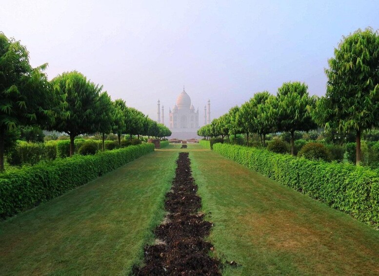 A garden pathway leading to a white domed building with minarets. 5