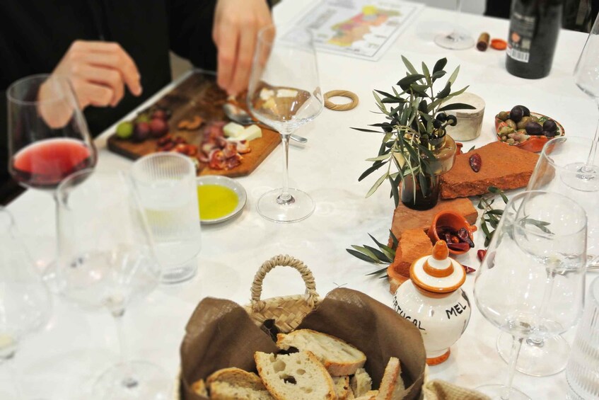 A table with food, wine glasses, and a basket of bread. 2
