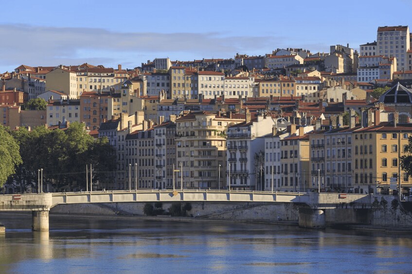 A bridge over a river with buildings in the background. 1