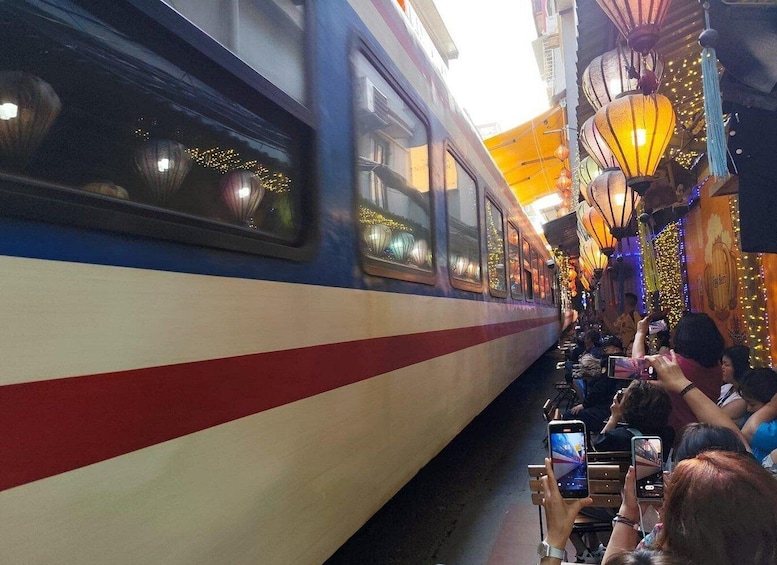 A train with passengers taking photos, decorated with lights and lanterns. 3