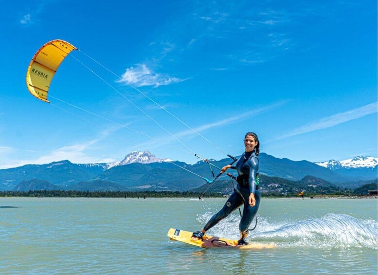 A person windsurfing on a lake with mountains in the background. 3