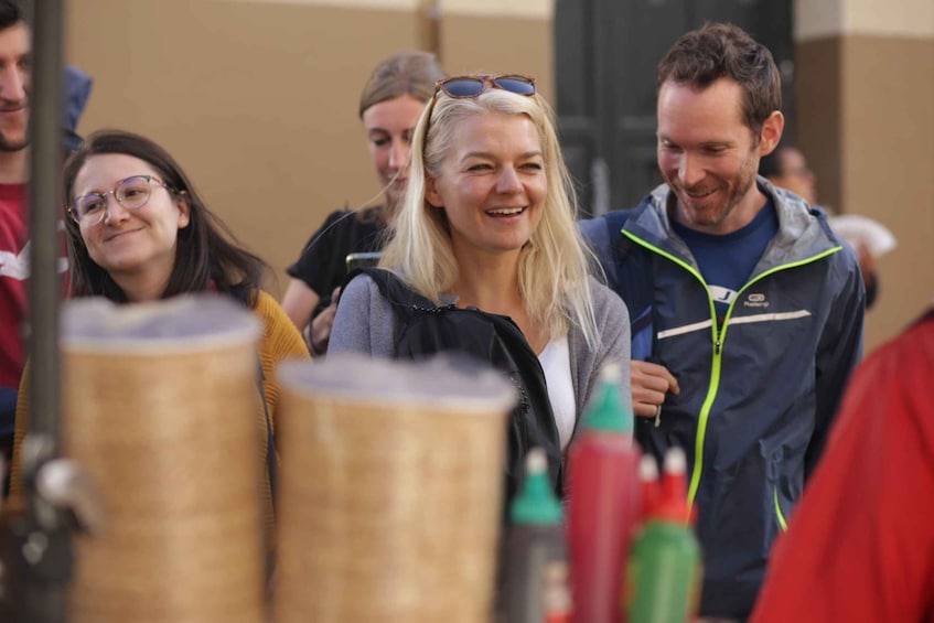 A group of people at an outdoor event with large cylindrical objects in the foreground. 5