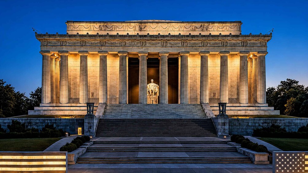 A classical building with columns and a statue in front. 2