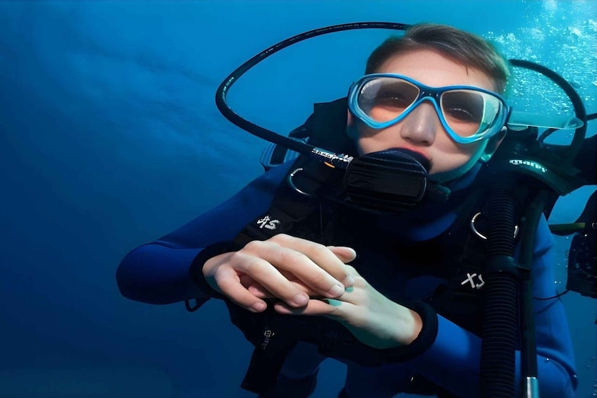A person underwater wearing a scuba diving mask and snorkel. 4