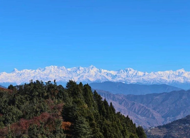 A mountain range with snow-capped peaks under a clear blue sky. 1