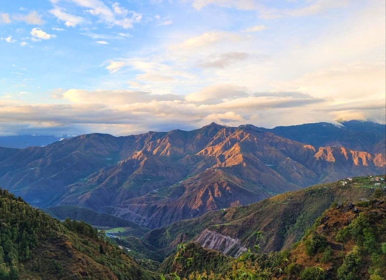 A mountainous landscape with a valley and a small settlement. 3