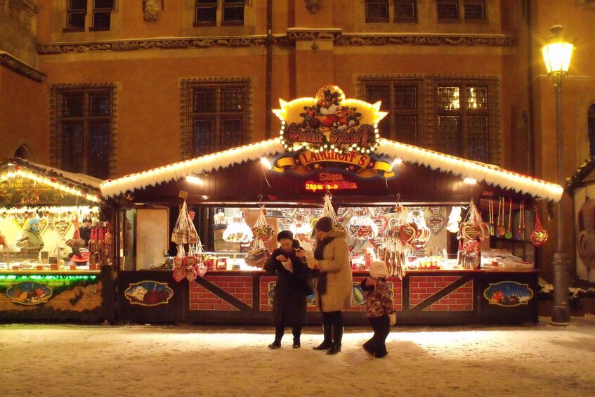 A brightly lit Christmas market stall with a sign reading "Schnitzel Special." 2