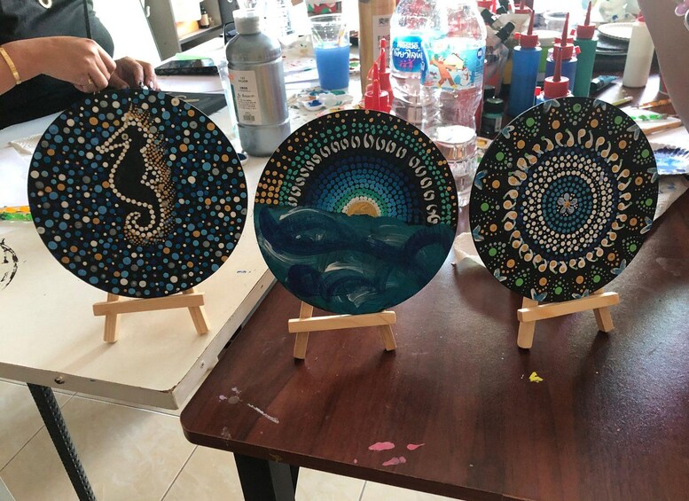 Three circular artworks on easels with different patterns and designs. 5