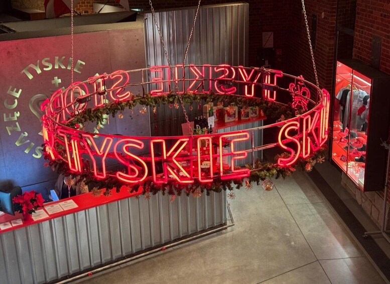 A neon sign spelling 'HARRY'S SKYSKY' in a circular arrangement, surrounded by greenery and flowers. 1