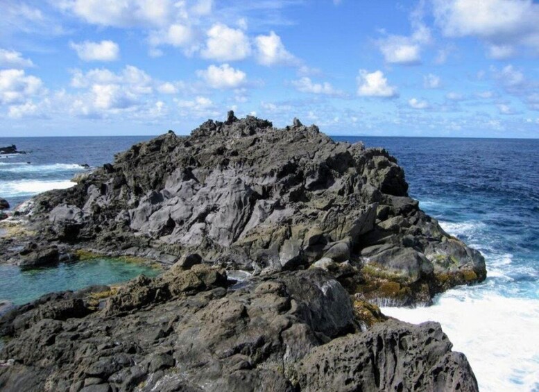 A rocky coastline with clear blue waters and a partly cloudy sky. 4