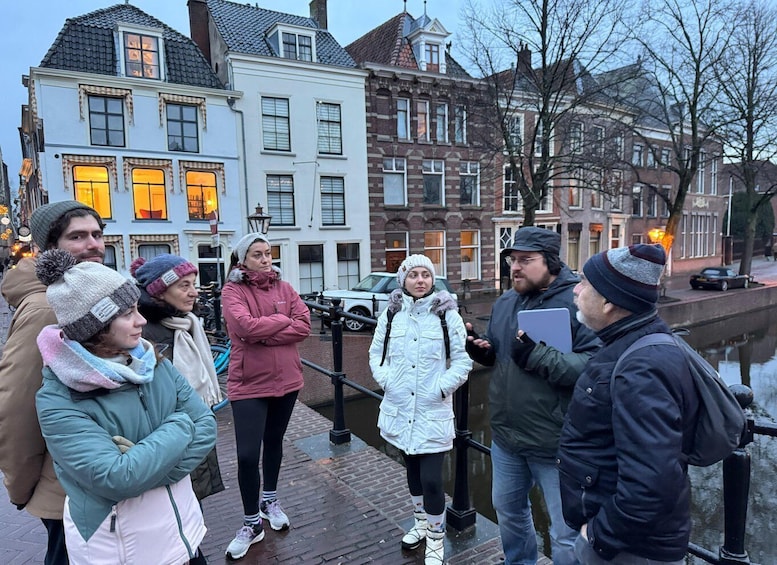 A group of people standing on a bridge in a city with historic buildings in the background. 2