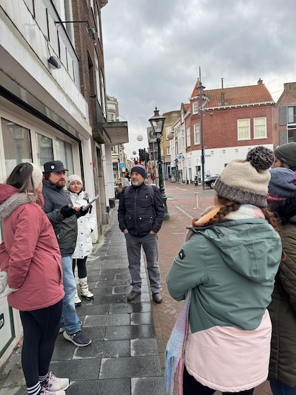 A group of people standing on a wet street in an urban area. 4