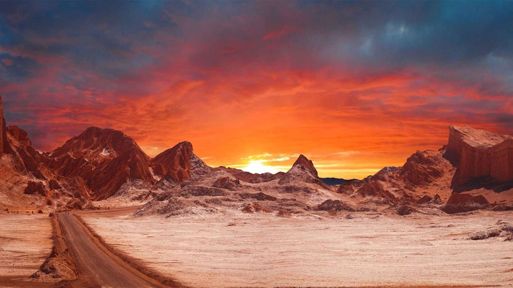 Paisaje desértico con un camino de tierra que se dirige hacia un atardecer. 2
