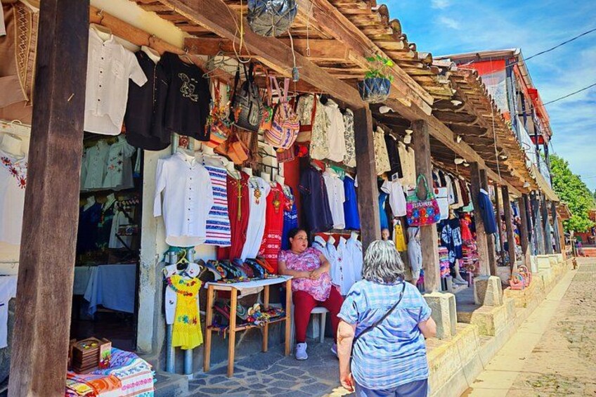 Un étal de marché où sont exposés divers articles de vêtements et accessoires. 4