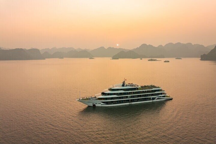 A large cruise ship on calm waters during sunset. 1