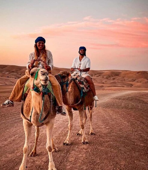 Two people riding camels in a desert landscape. 4