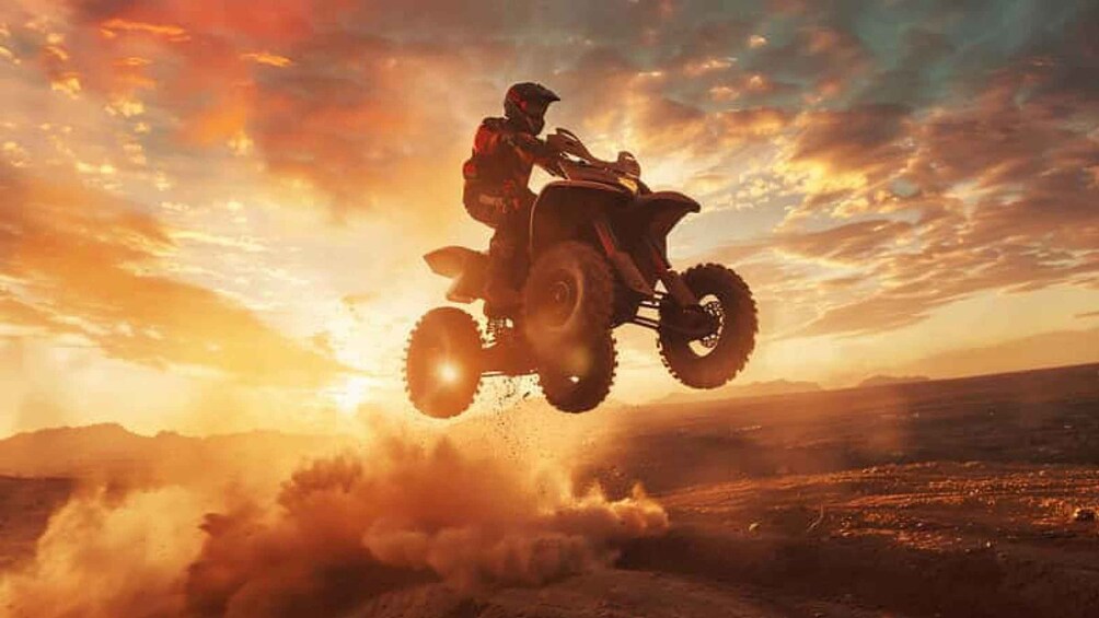 A person riding a quad bike in mid-air over a dusty terrain with a sunset in the background. 5