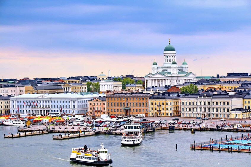 A harbor with boats, a large white building with a green dome, and colorful buildings along the waterfront. 4