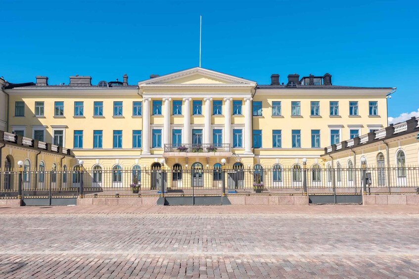 A large yellow building with columns and a flagpole. 5