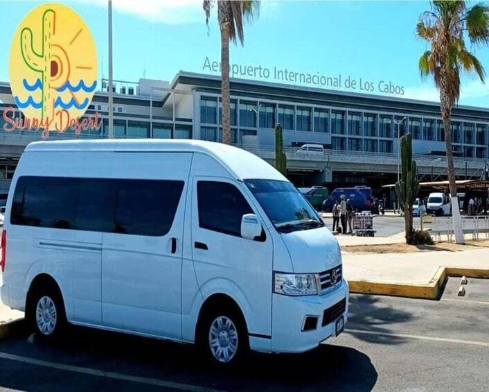 A white van parked in front of a building with a sign reading "Aeroporto Internacional de Los Cabos". 2