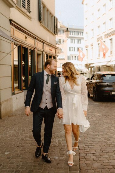 A couple walking on a cobblestone street, holding hands. 2