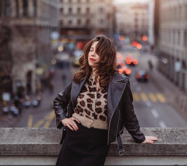 A person leaning on a stone wall with a city street in the background. 5