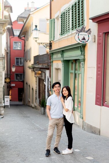 A couple standing on a cobblestone street with colorful buildings. 3