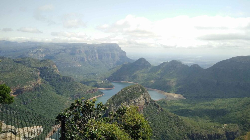 A mountainous landscape with a river winding through valleys and a distant view of a city skyline. 2