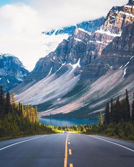 A road leading to a mountainous landscape with a lake. 4